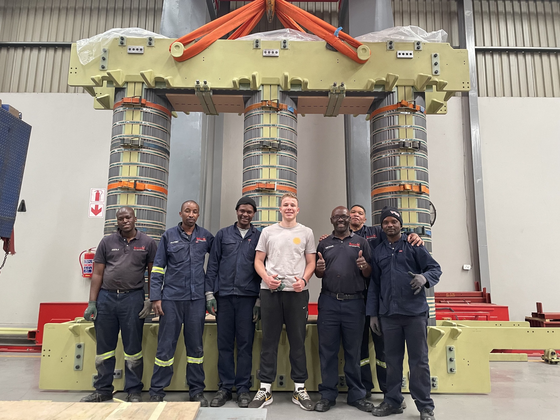 Matteo Buxman with the assembly team in front of a three-limb power transformer core in the workshop